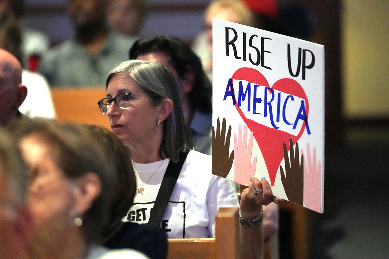 Janie Libanoff holds a sign during a town hall held by David Jolly
